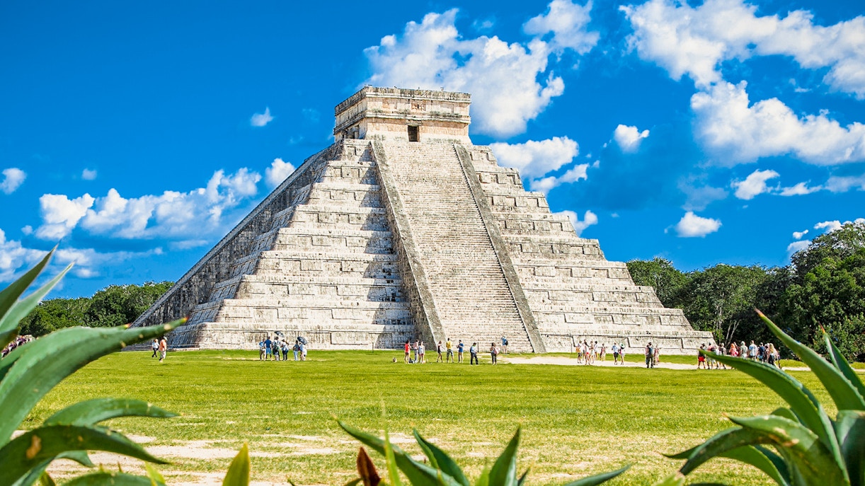Chichen Itza pyramid with tourists exploring the site in Mexico.