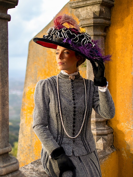 Person in period costume at Palace of Pena, Sintra, Portugal, during theatrical tour.