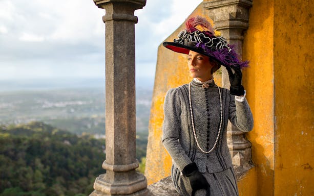 Person in period costume at Palace of Pena, Sintra, Portugal, during theatrical tour.