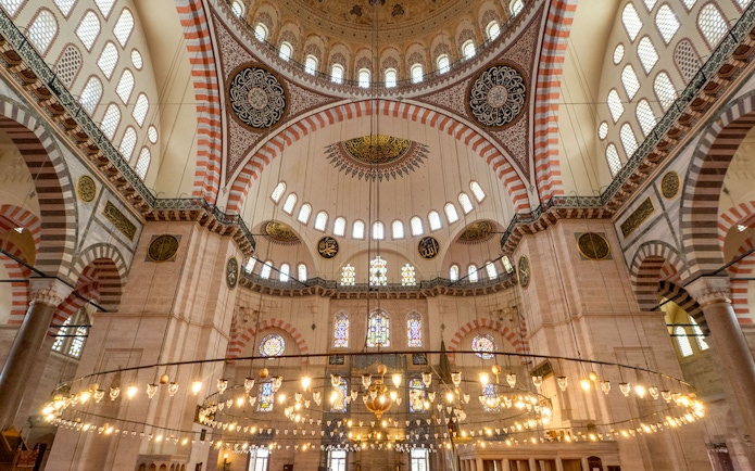 Interior of Blue Mosque with ornate domes and stained glass windows, Istanbul.