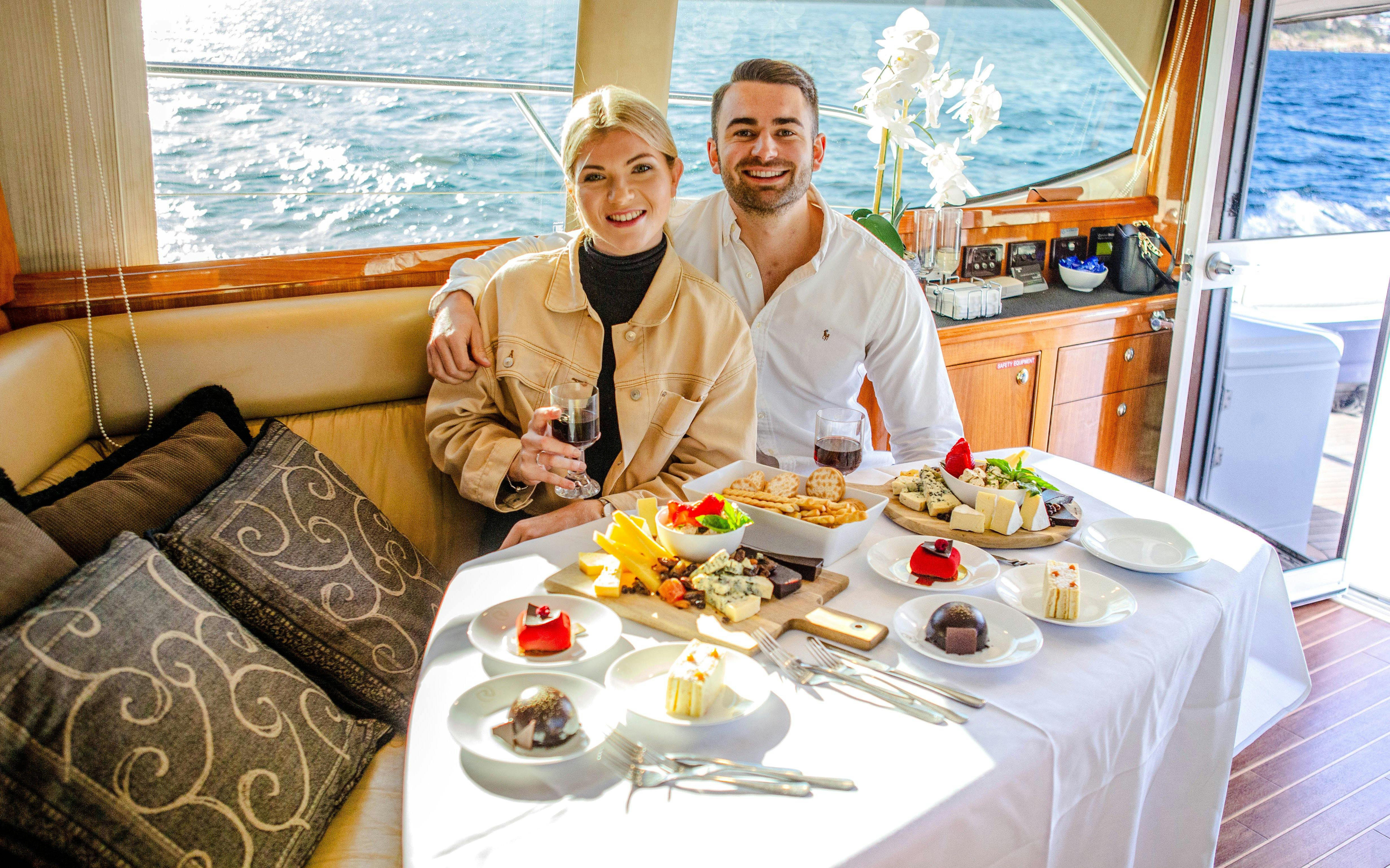 Couple enjoying a gourmet lunch on a private yacht during Sydney Harbour luxury cruise.