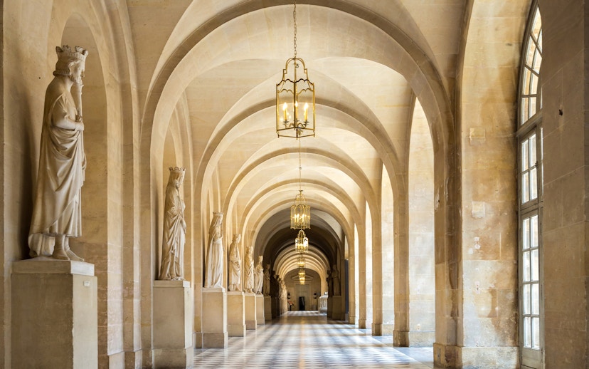 Corridor with statues and arches in Versailles Palace, France.