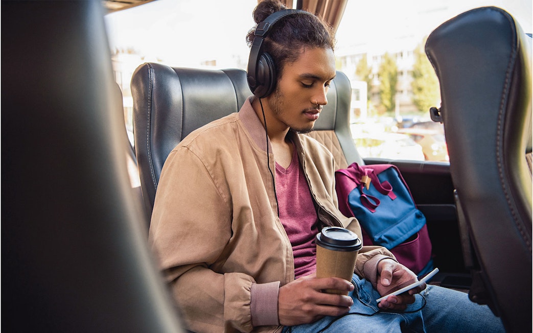 Passenger using wifi and enjoying a drink on a bus from Naples Metropark to Rome Tiburtina.