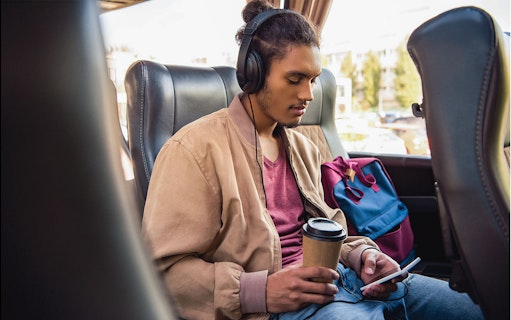 Passenger using wifi and enjoying a drink on a bus from Naples Metropark to Rome Tiburtina.