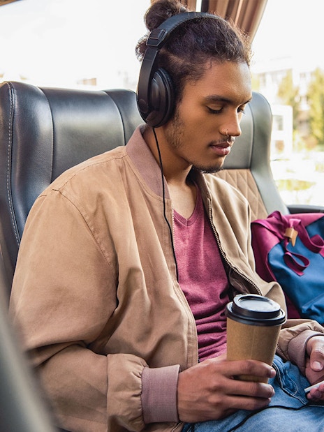 Passenger using wifi and enjoying a drink on a bus from Naples Metropark to Rome Tiburtina.
