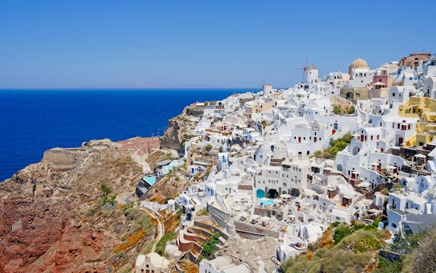 Santorini's white buildings and blue sea on a semi-private city tour.