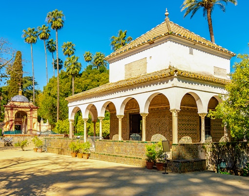 Pavilion in Seville Alcazar gardens with arches and tilework, Spain.