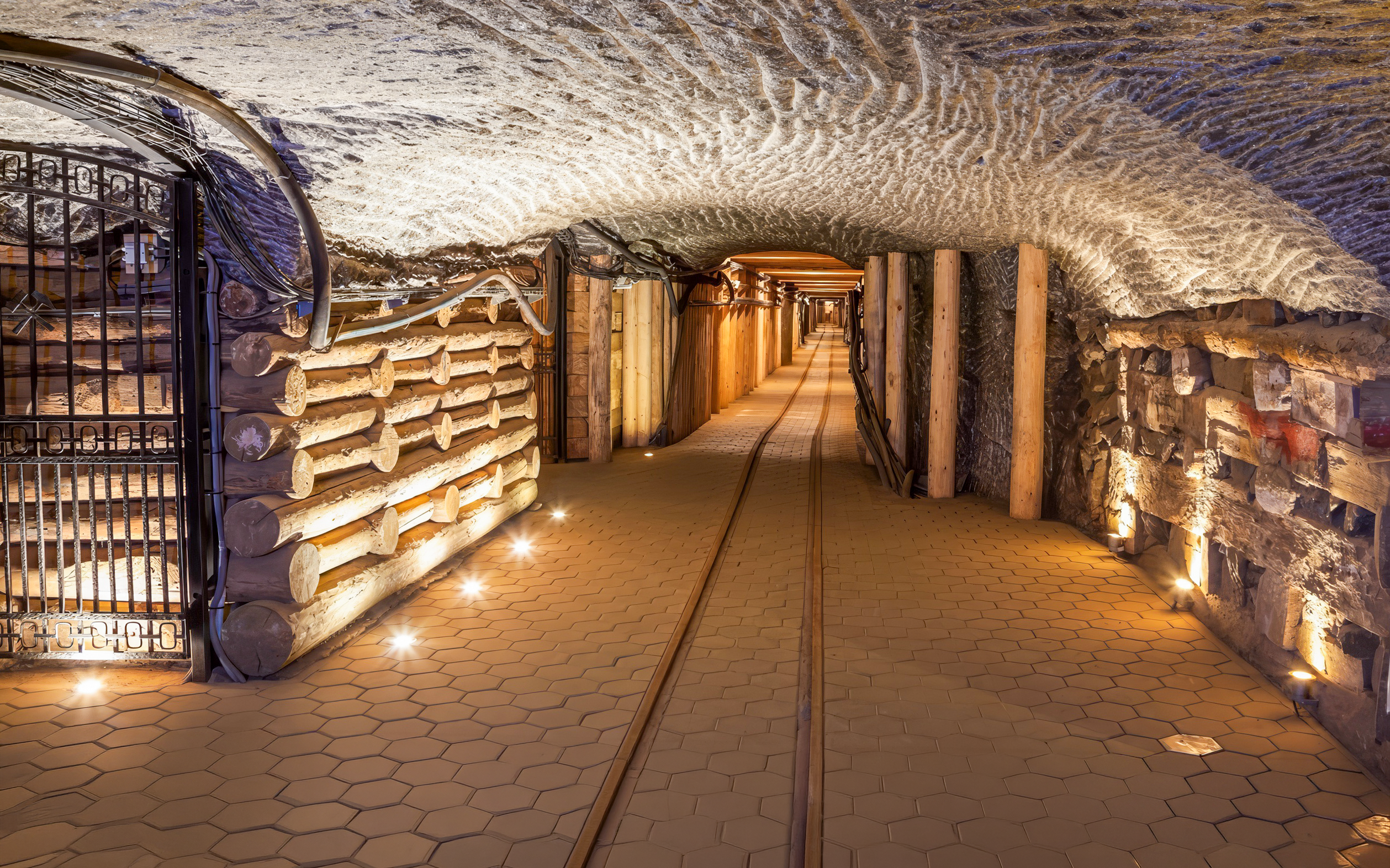 Wieliczka Salt Mine tunnel with wooden supports and illuminated pathway in Poland.