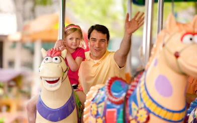 Father and daughter on carousel ride at Sesame Place San Diego.