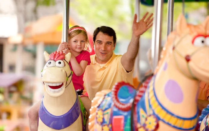 Father and daughter on carousel ride at Sesame Place San Diego.
