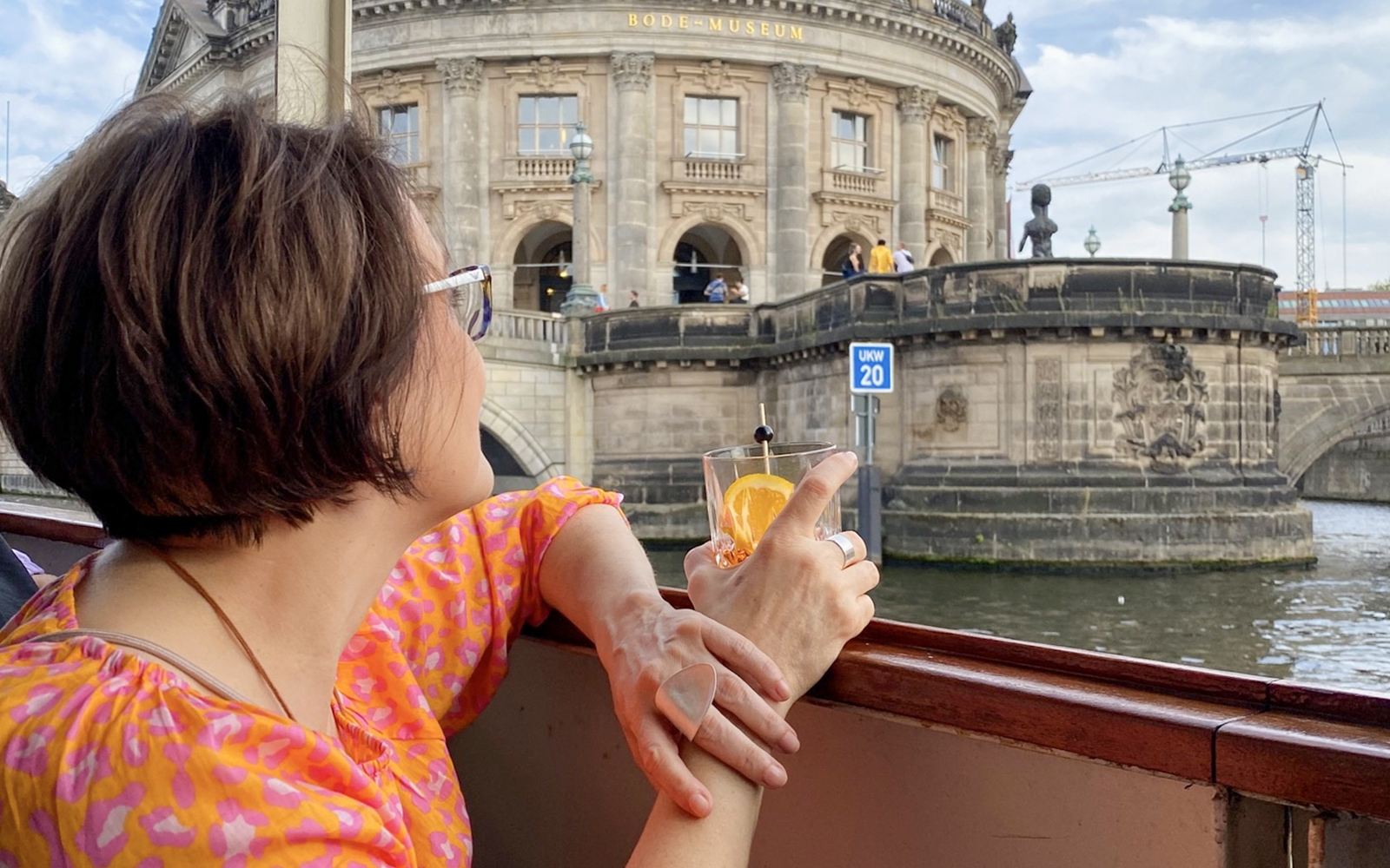 Guests enjoying drinks on a Berlin sightseeing cruise near Bode Museum.