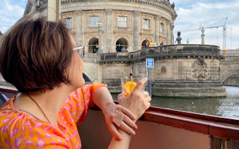 Guests enjoying drinks on a Berlin sightseeing cruise near Bode Museum.