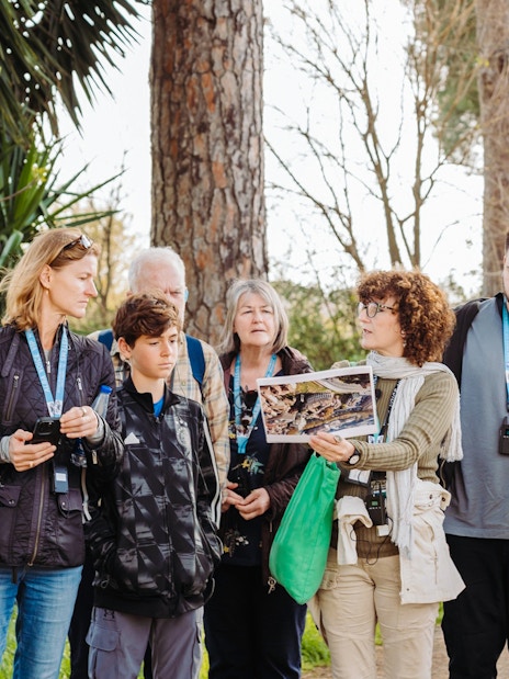 Tour guide briefing tourists about Rome Catacombs and Appian Way.