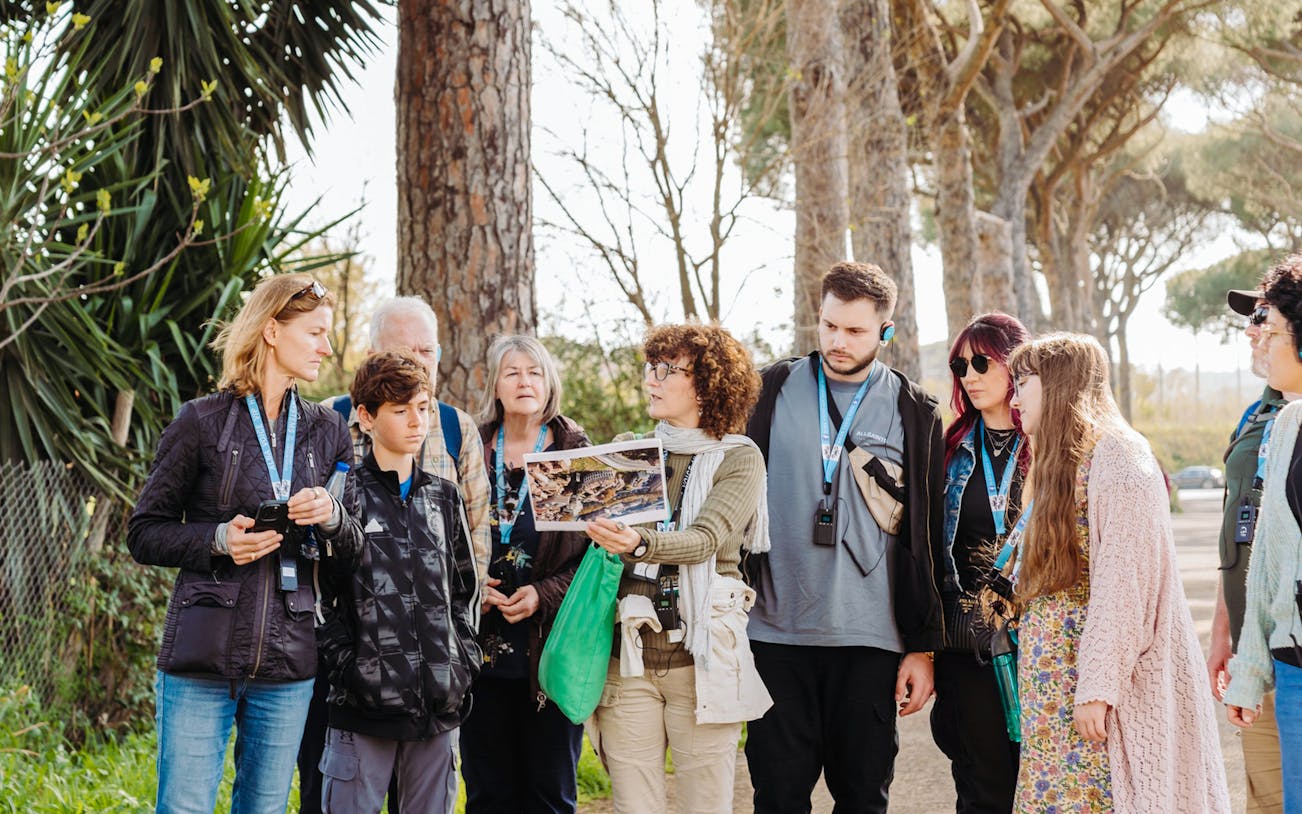 Tour guide briefing tourists about Rome Catacombs and Appian Way.