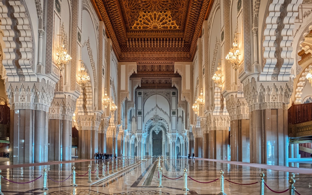 Internal corridor of Hassan II Mosque with ornate arches and chandeliers, Casablanca, Morocco.