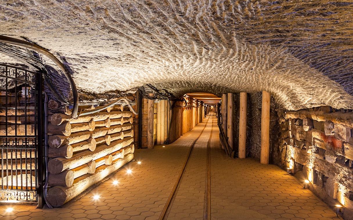 Wieliczka Salt Mine underground passageway with illuminated walls and wooden supports.