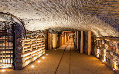 Wieliczka Salt Mine underground passageway with illuminated walls and wooden supports.