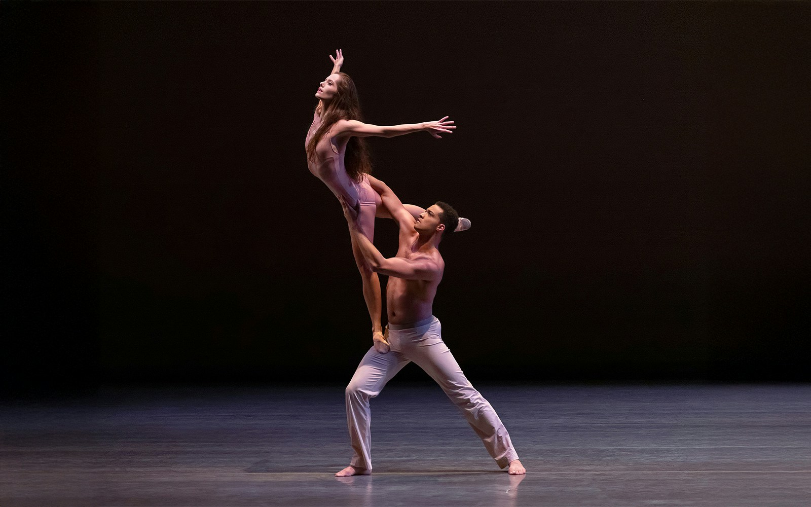 Ballet dancers performing a lift on stage at New York City Ballet.