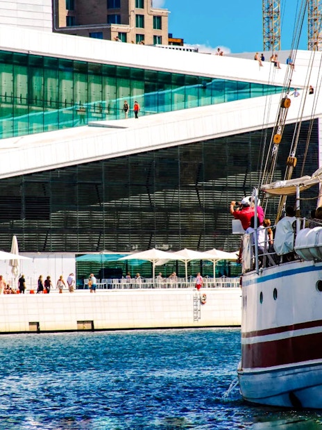 Sailing ship near Oslo Opera House, Norway, with people on deck.