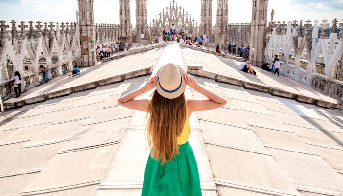 Milan Duomo rooftop with tourists enjoying cityscape, part of City Sightseeing Milan Hop-On Hop-Off Tour.