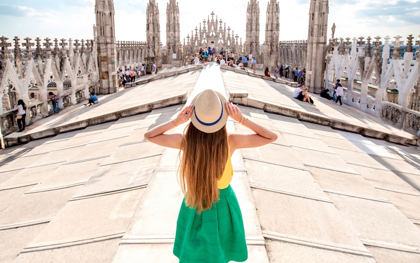 Milan Duomo rooftop with tourists enjoying cityscape, part of City Sightseeing Milan Hop-On Hop-Off Tour.