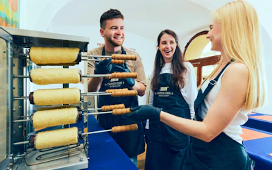 Participants making chimney cakes at a workshop in Budapest.