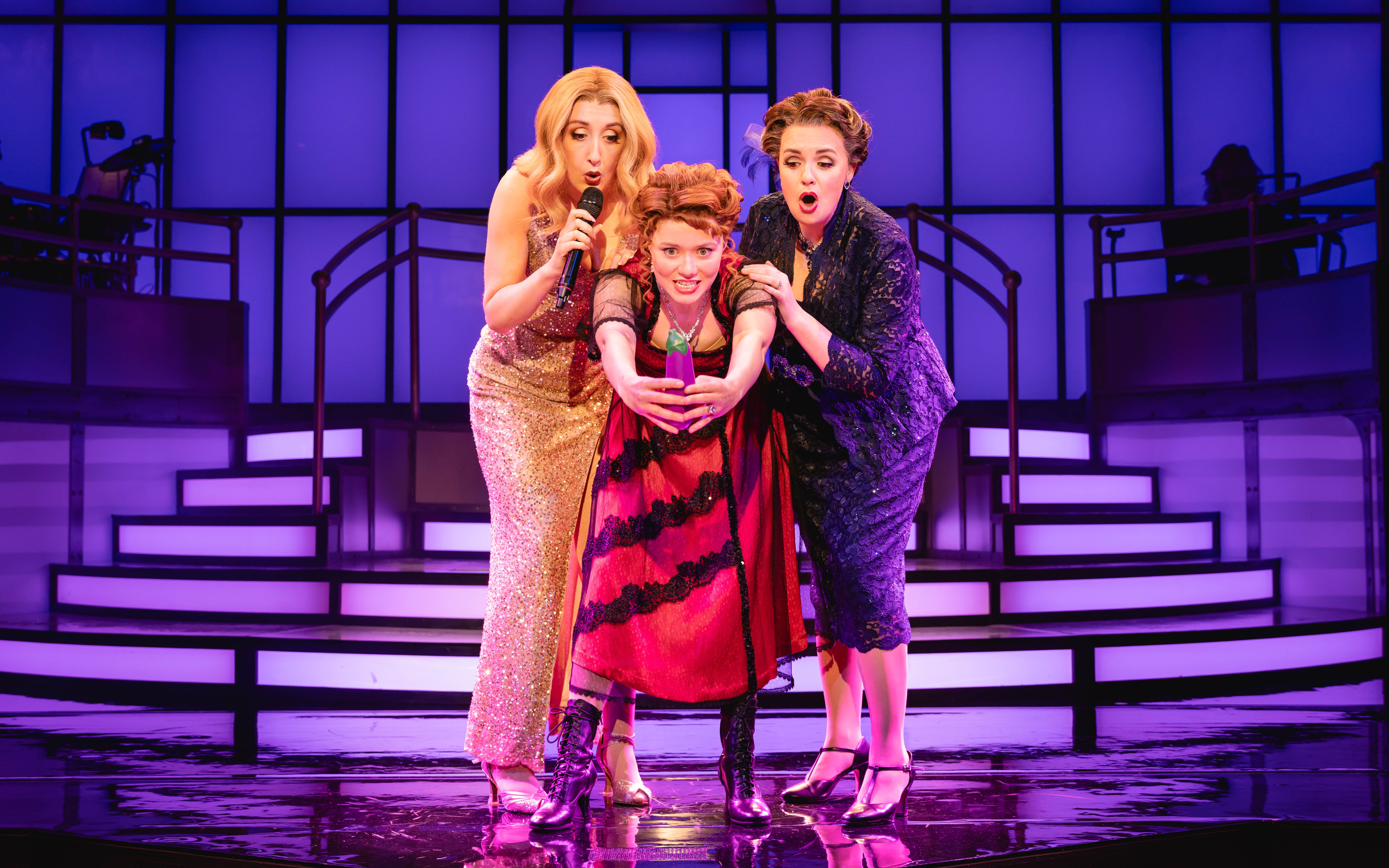 Stage performance of Titanique Westend with three actors on a vibrant set.