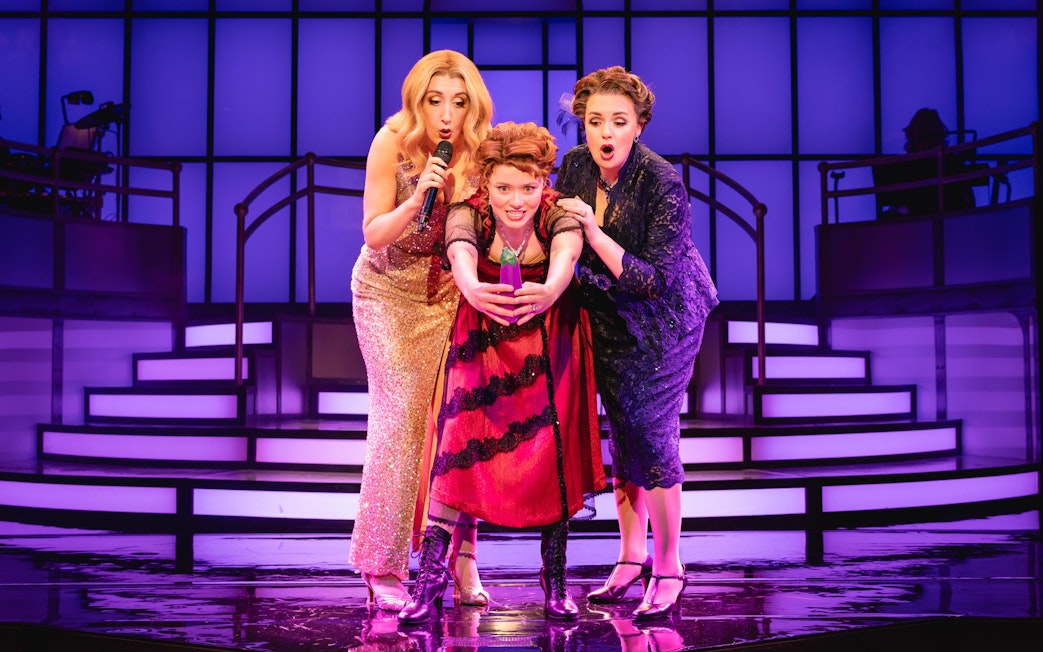 Stage performance of Titanique Westend with three actors on a vibrant set.