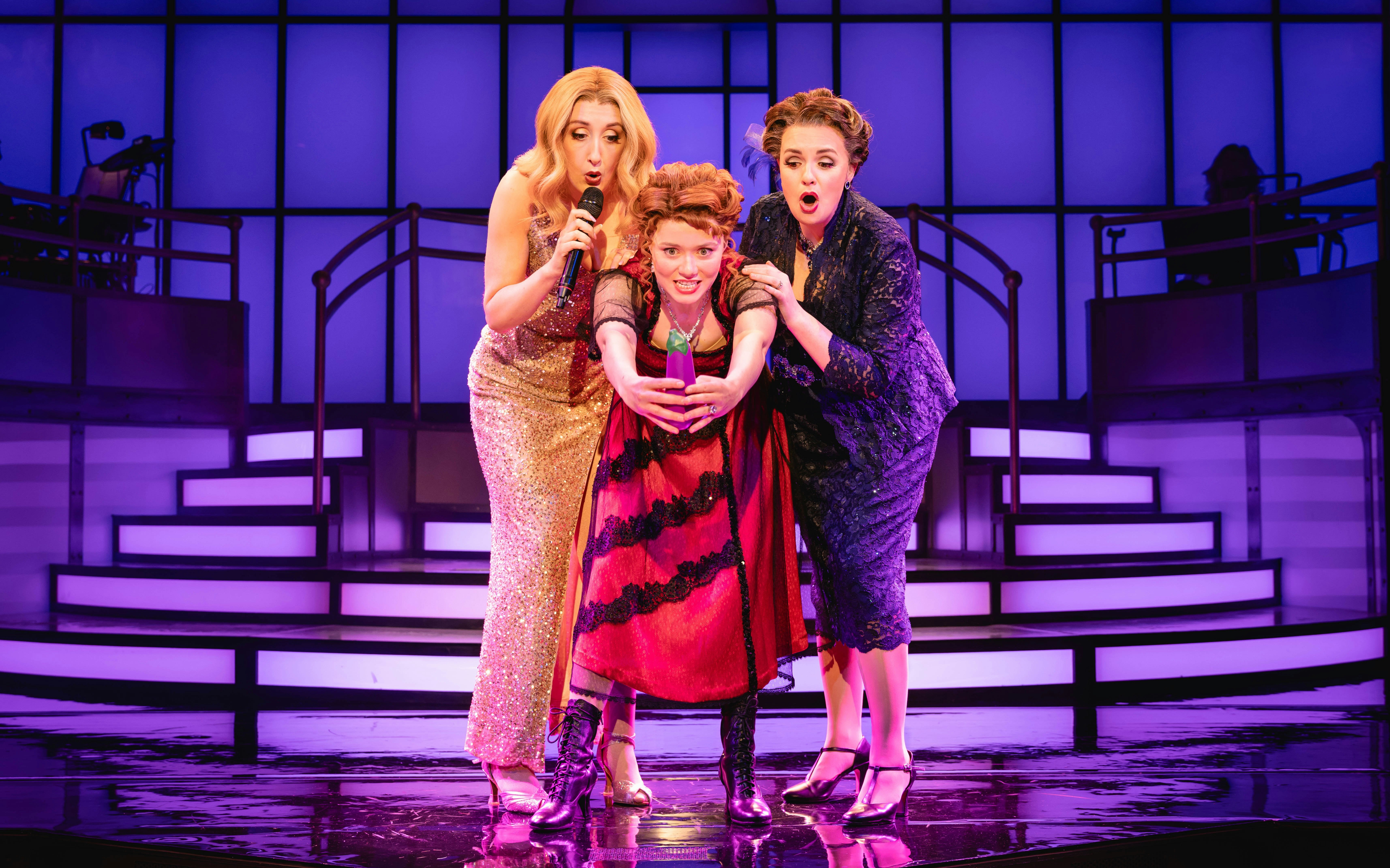 Stage performance of Titanique Westend with three actors on a vibrant set.