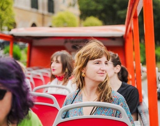 Woman on a hop on hop off open deck bus, Chester