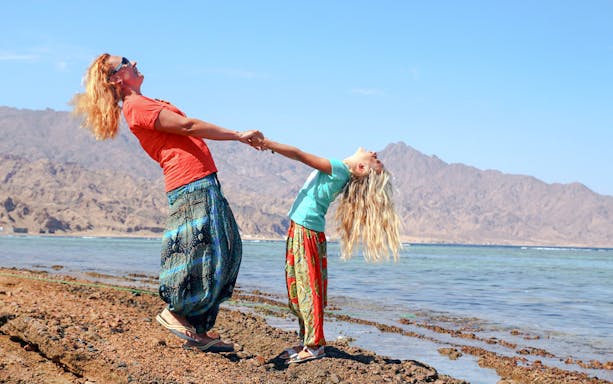 Family enjoying Magic Lake at Ras Muhammad National Park, Egypt, surrounded by desert landscape.