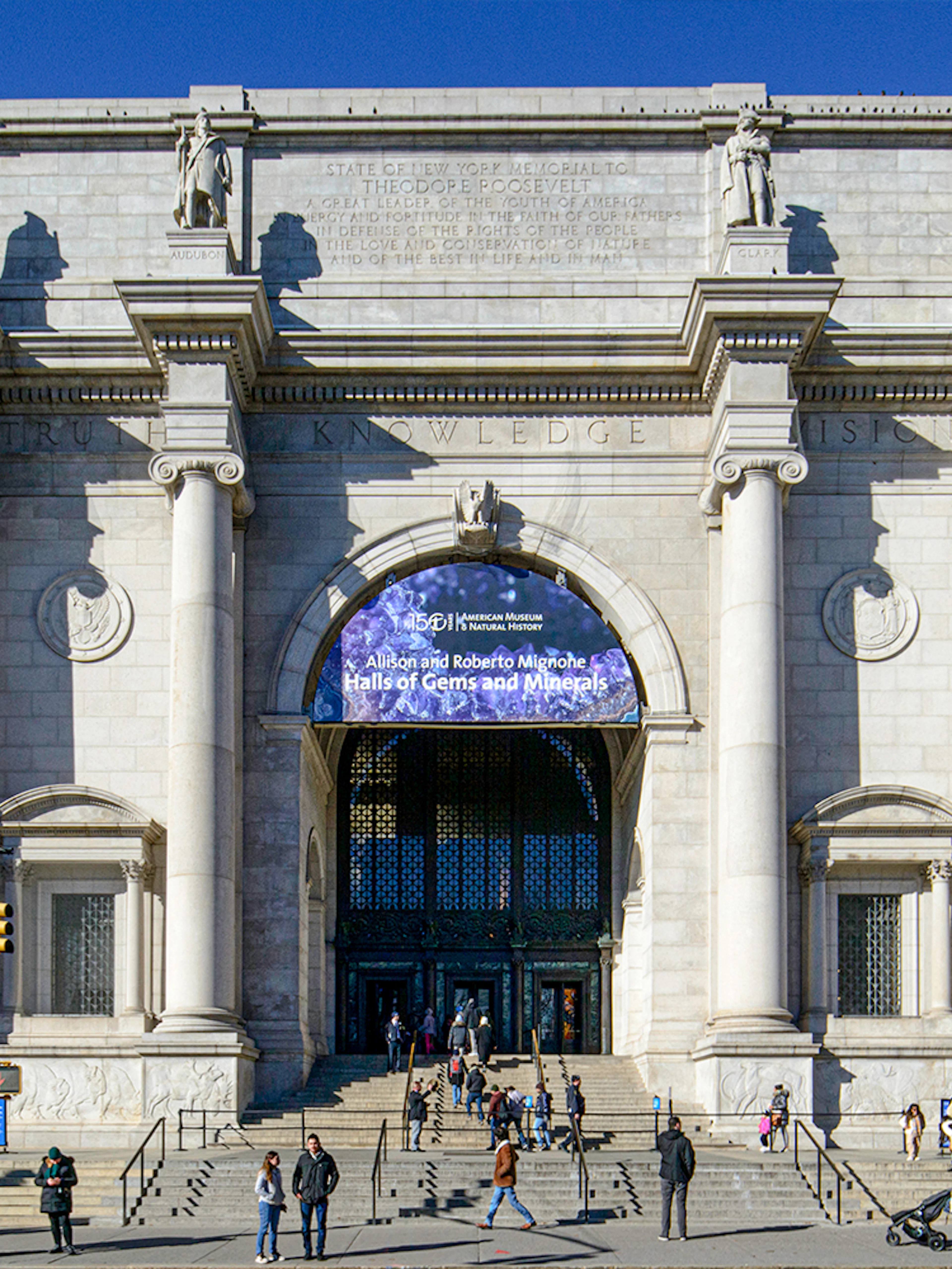 American Museum of Natural History entrance, New York City, with visitors outside.