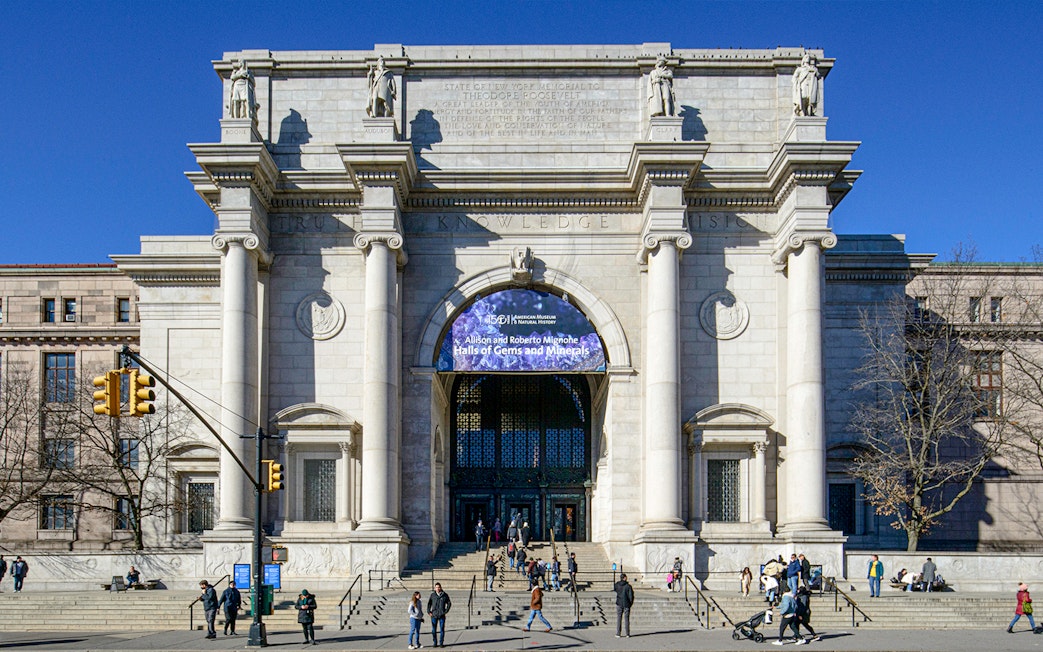 American Museum of Natural History entrance, New York City, with visitors outside.
