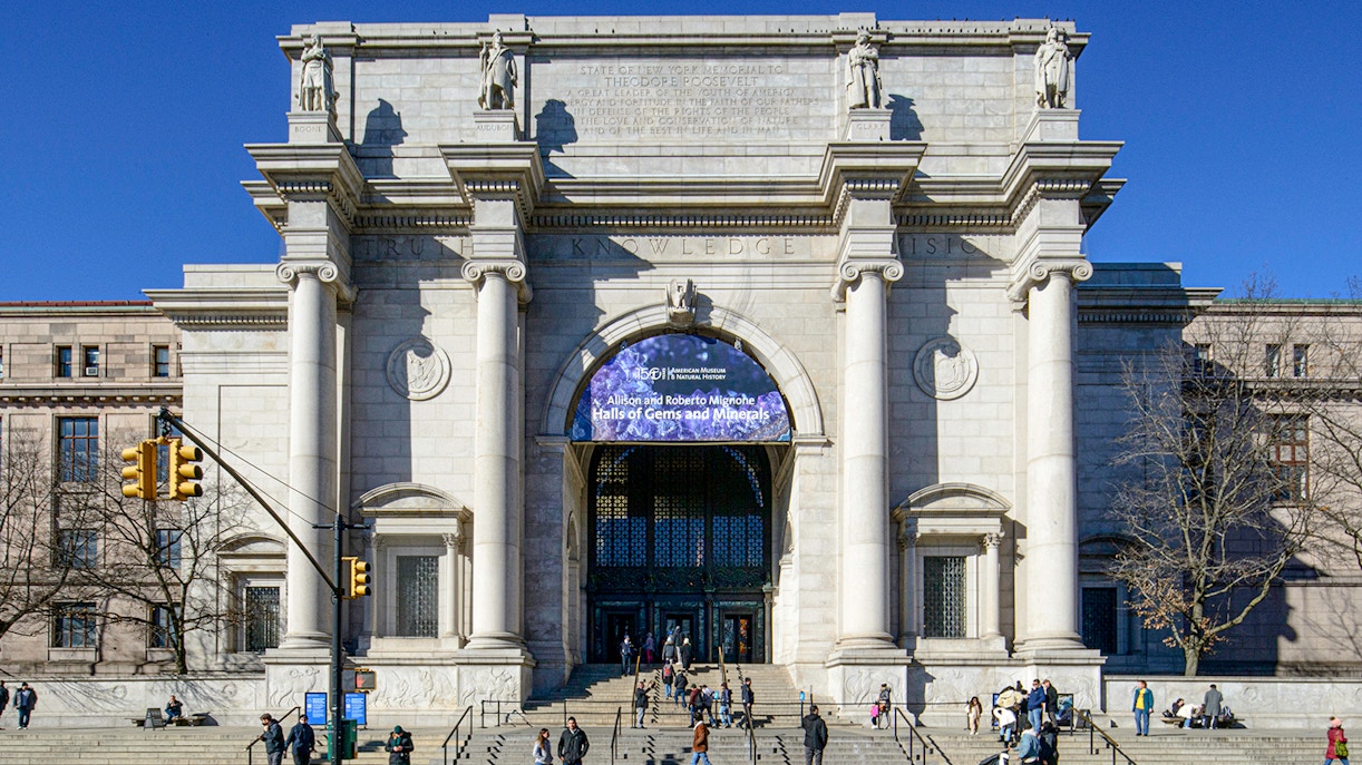 American Museum of Natural History entrance, New York City, with visitors outside.