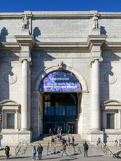 American Museum of Natural History entrance, New York City, with visitors outside.