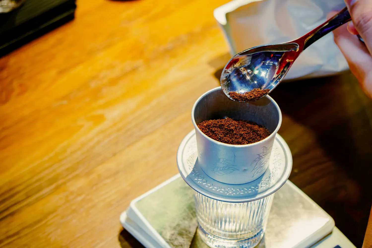 Phin filter with ground coffee for Hanoi egg, coconut, and salt coffee experience.