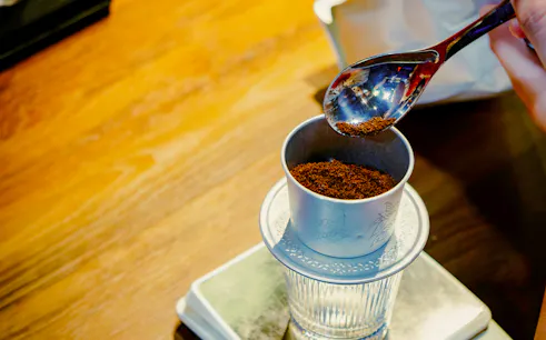 Phin filter with ground coffee for Hanoi egg, coconut, and salt coffee experience.