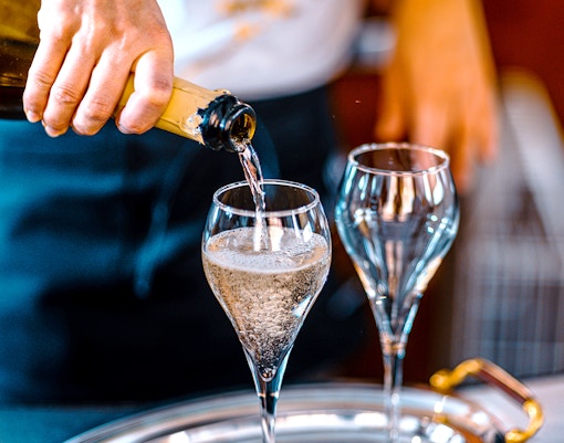 Pouring cava into glasses during a Barcelona day tour.