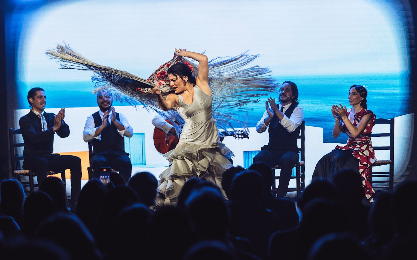 Flamenco dancers performing at Teatro Flamenco Barcelona with musicians clapping.