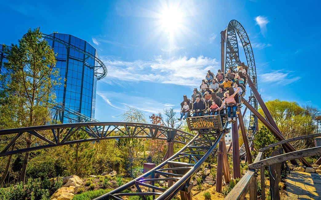 Rollercoaster riders on the Voltron Nevera in Croatia-themed area under a sunny sky.