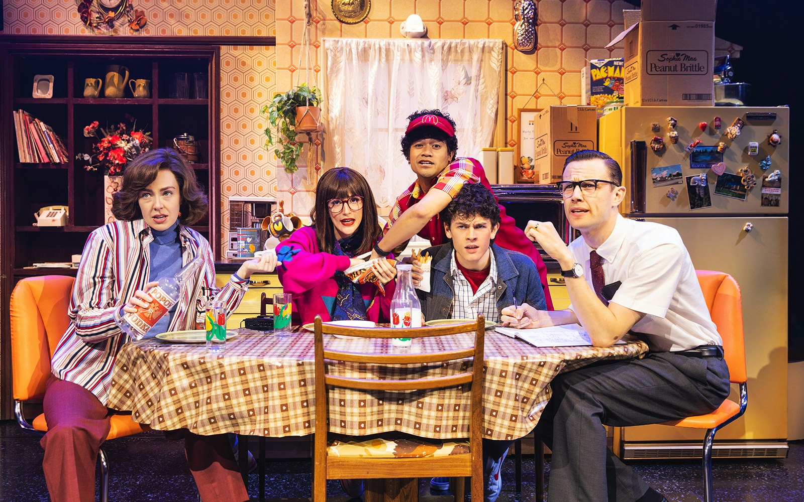 Cast members of Back to the Future the Musical in a retro kitchen scene.