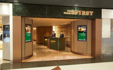 First-Class Lounge entrance at Hong Kong International Airport with reception desk.