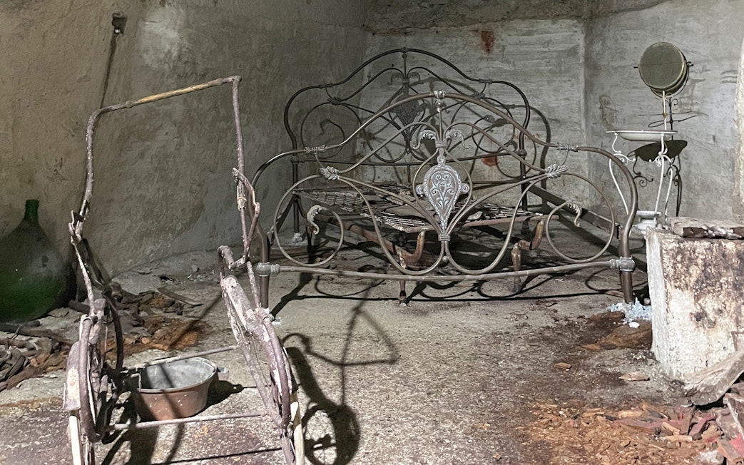Antique metal bed frame in Naples Underground cave setting.