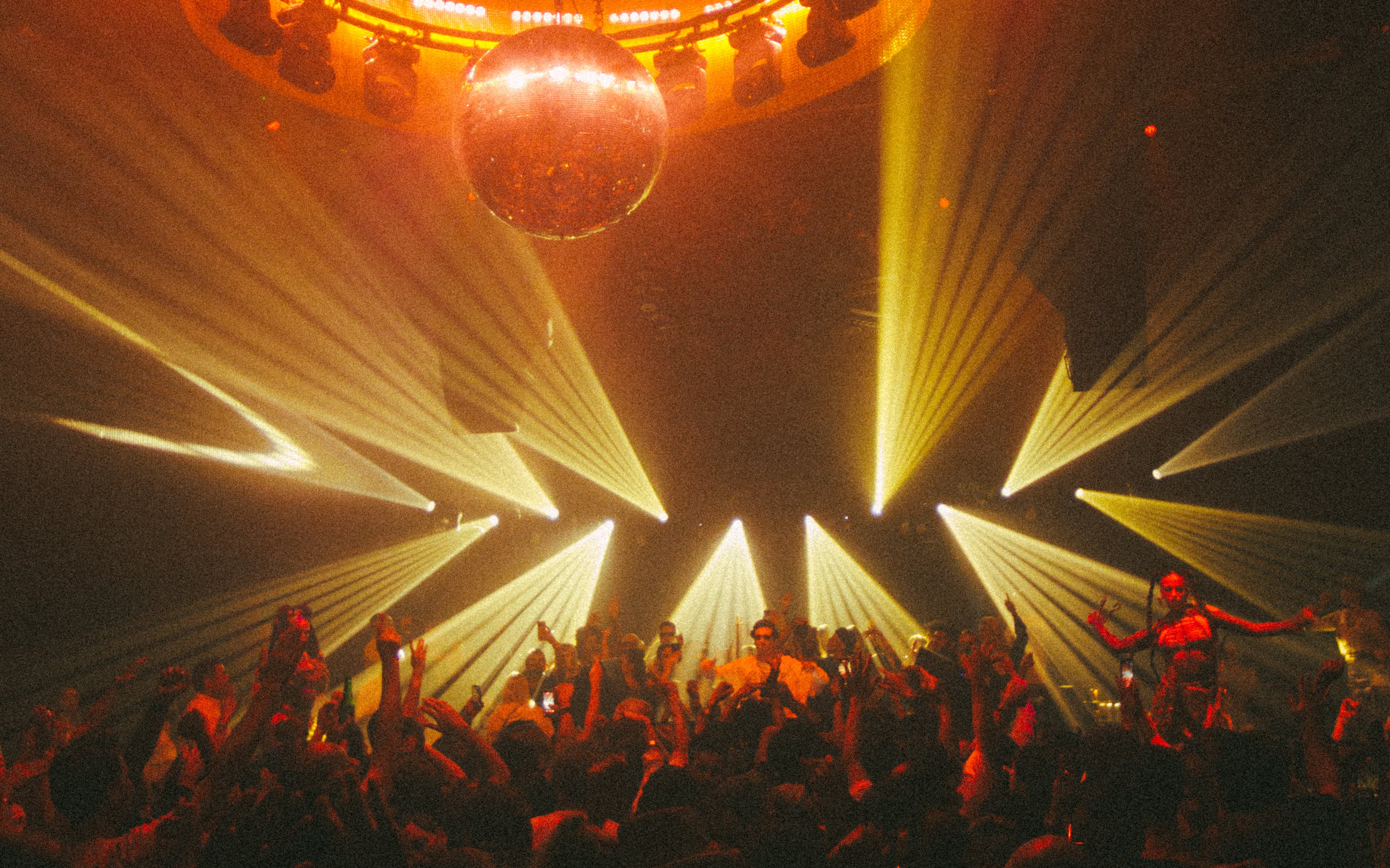 DJ performing at La Troya Club Chinois, Ibiza with vibrant lights and crowd dancing.