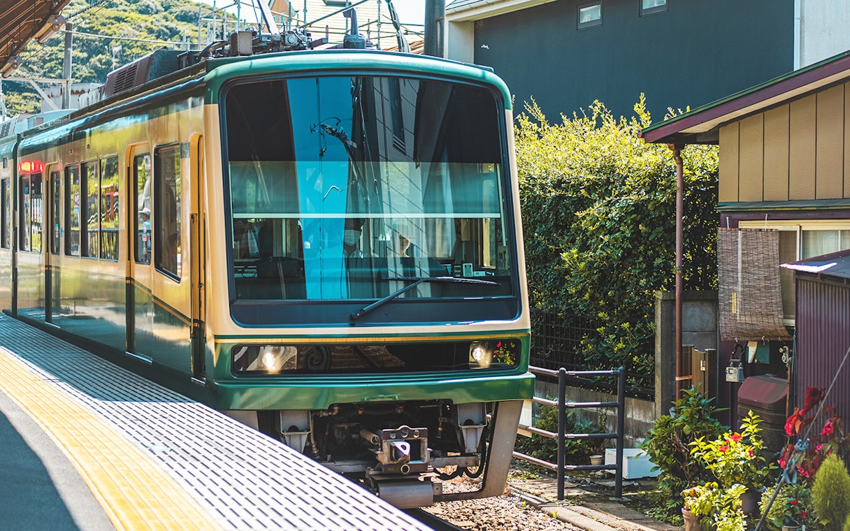 Enoden tram at a station in Kamakura during a 1-day guided tour.