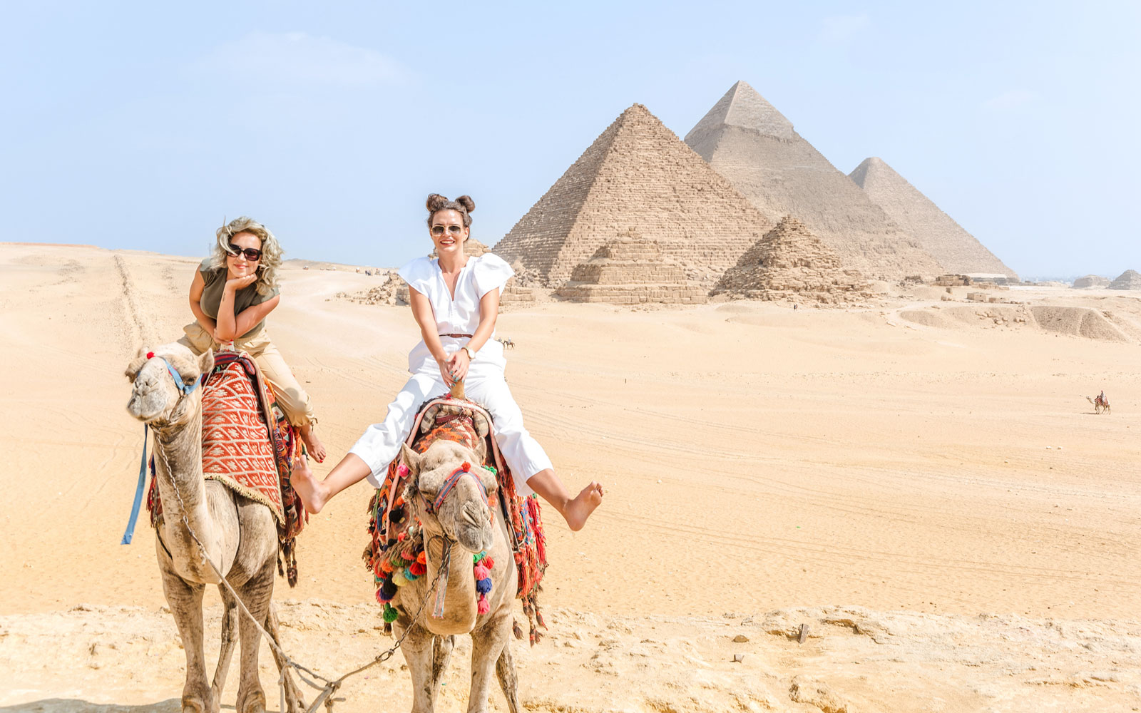 Tourists riding camels near the Giza Pyramids in Egypt.