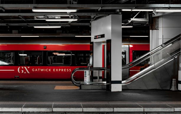 Gatwick Express train at platform with escalator at Gatwick Airport station.