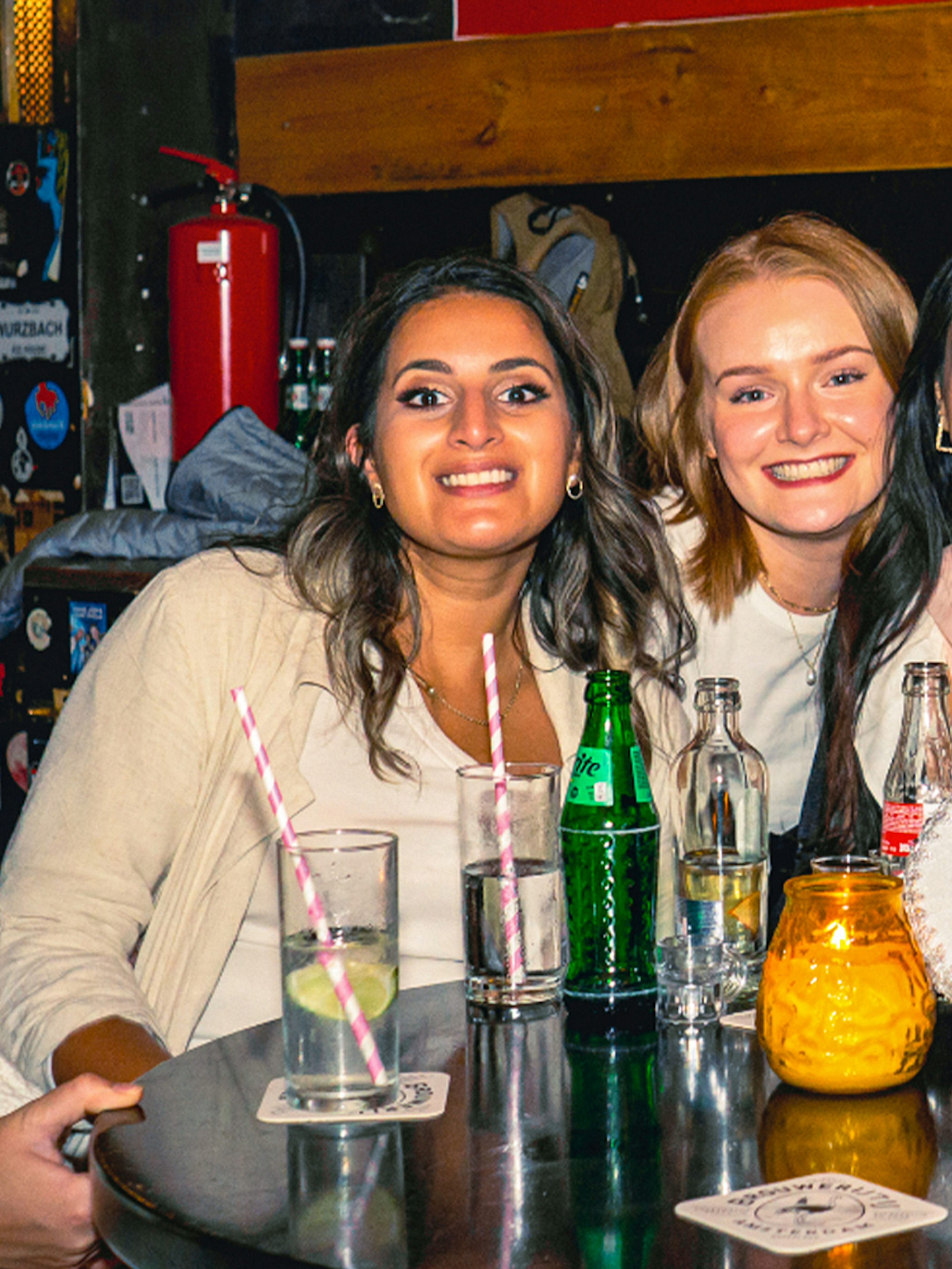 Tourists enjoying drinks at a pub in Amsterdam's Red Light District during a pub crawl.
