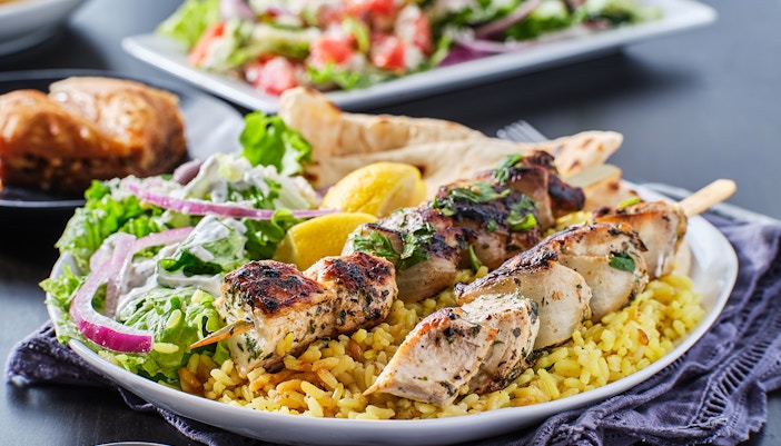 Grilled chicken skewers on rice with salad and lemon, Mediterranean BBQ.
