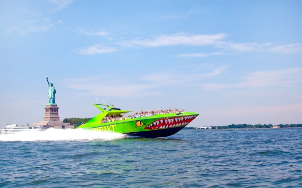 Speedboat "The Beast" with guests near Statue of Liberty, NYC.